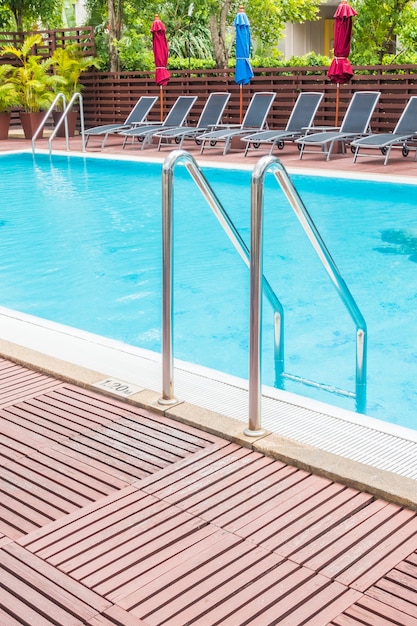 Foto grátis piscina com espreguiçadeiras dispostas em fileira