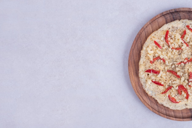 Pizza com pimentão na placa de madeira na superfície branca