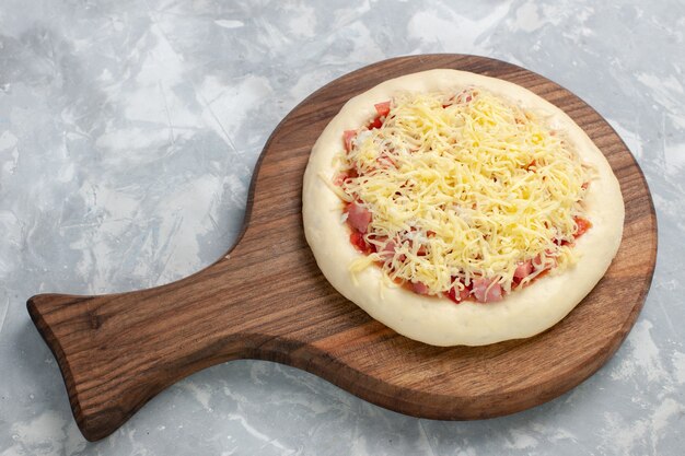 Pizza crua de cima com molho de tomate e queijo no branco