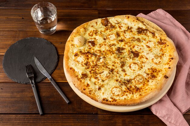 Pizza de ângulo alto com queijo e talheres