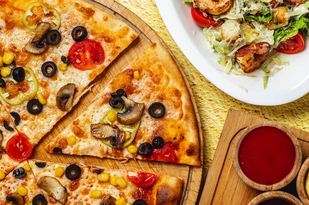 Pizza de cogumelos vista superior com azeitona preta milho pimentão tomate e queijo em uma placa