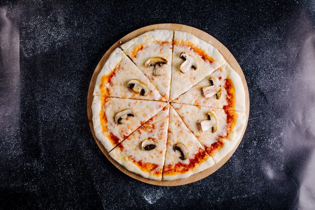 Pizza de molho de cogumelos, queijo, tomate cortada em fatias.