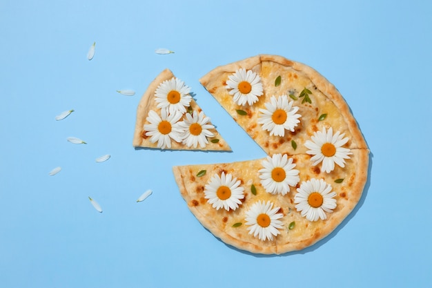 Foto grátis pizza de vista superior com flores sobre fundo azul