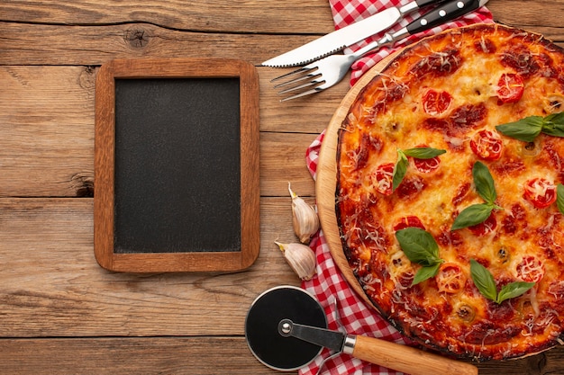 Foto grátis pizza deliciosa com quadro negro vista de cima