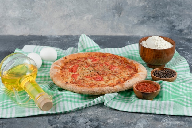 Pizza deliciosa de queijo e tomate com farinha e ovo em fundo de pedra.