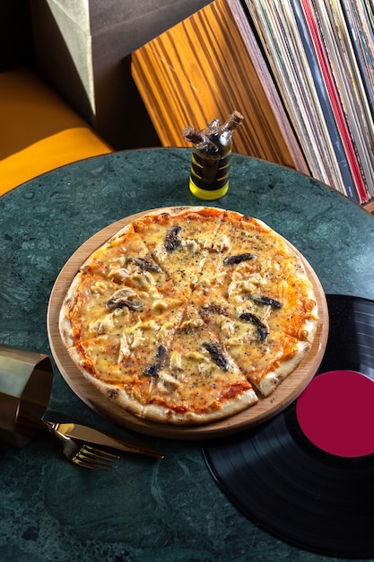 Pizza fatiada com cogumelos, tomate e queijo em cima da mesa refeição fast-food