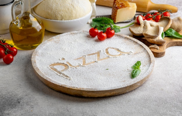 Pizza palavra escrita em farinha numa placa de madeira