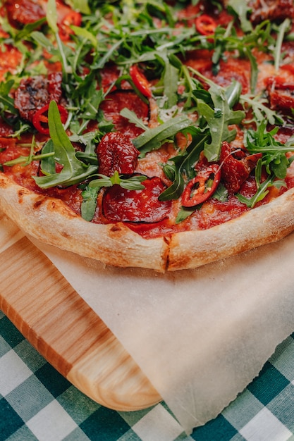 Pizza picante napolitana com presunto, queijo, rúcula, manjericão, tomate, pimenta calabresa pulverizada com queijo