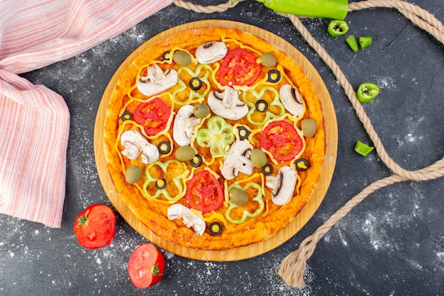 Pizza saborosa de cogumelos com tomates vermelhos azeitonas cogumelos com tomates frescos em toda a mesa cinza pizza italiana