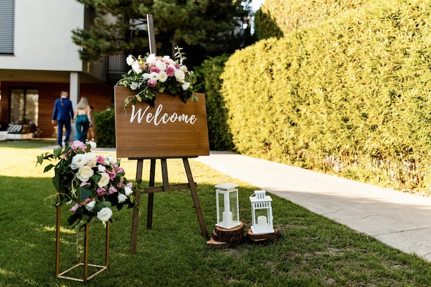 Placa de boas-vindas na recepção de casamento em um jardim.