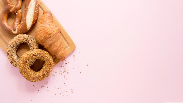 Placa de madeira com espaço para texto e pretzel e croissant