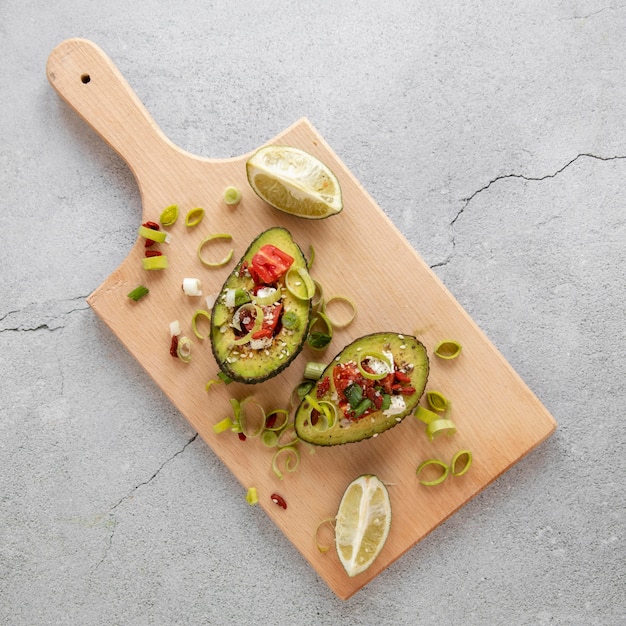 Placa de madeira com salada de abacate na mesa
