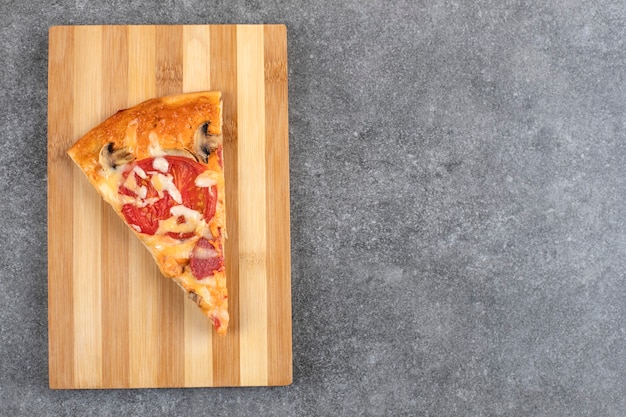 Placa de madeira de saborosa pizza caseira na mesa de pedra.