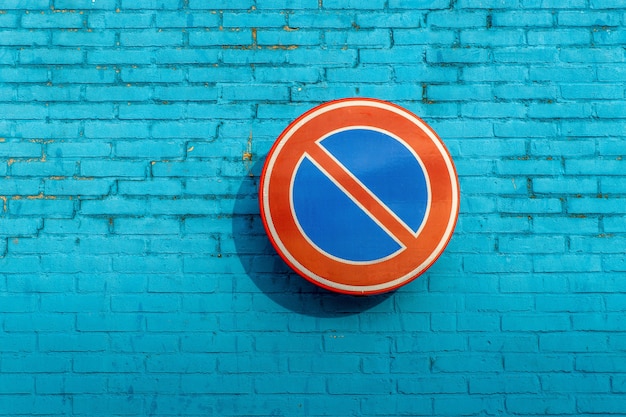Placa de proibição de espera em parede de tijolo azul