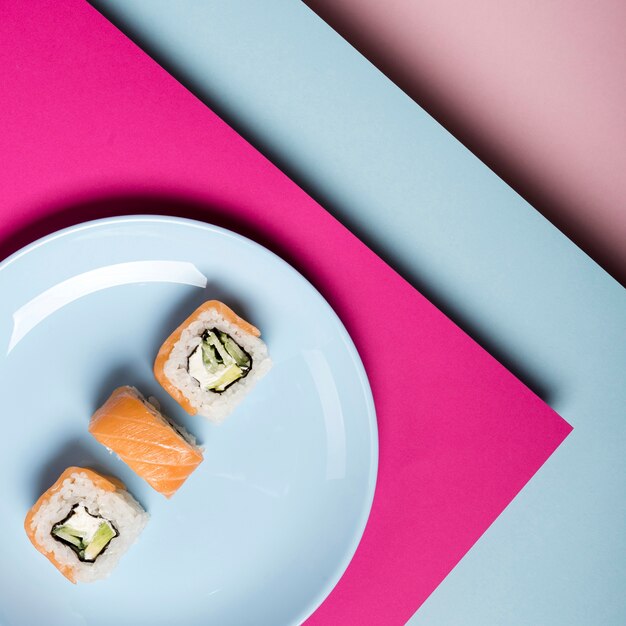 Placa minimalista com vista superior de rolos de sushi