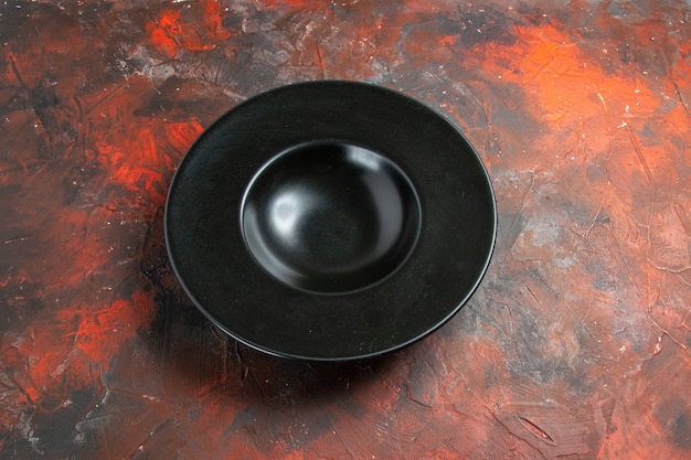 Foto grátis placa oval preta de vista inferior no espaço de cópia da mesa vermelho escuro
