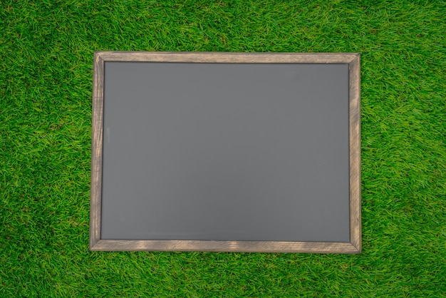 Foto grátis placa preta em branco no campo de grama