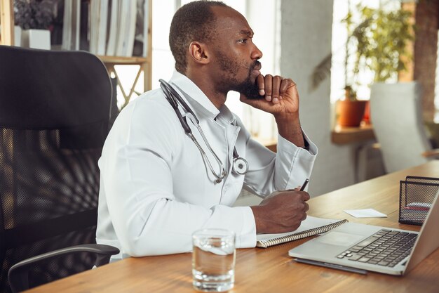 Plano aproximado de médico afro-americano para paciente que trabalha em gabinete