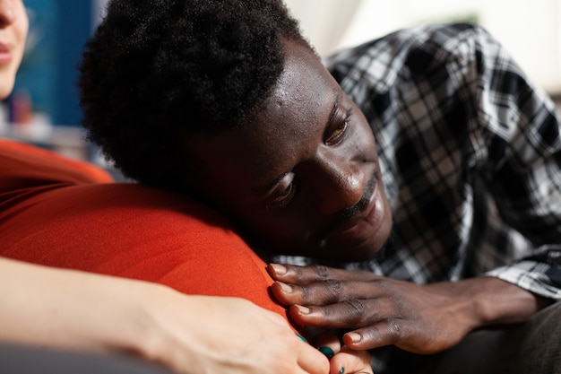 Plano aproximado de pai negro de criança tocando a barriga