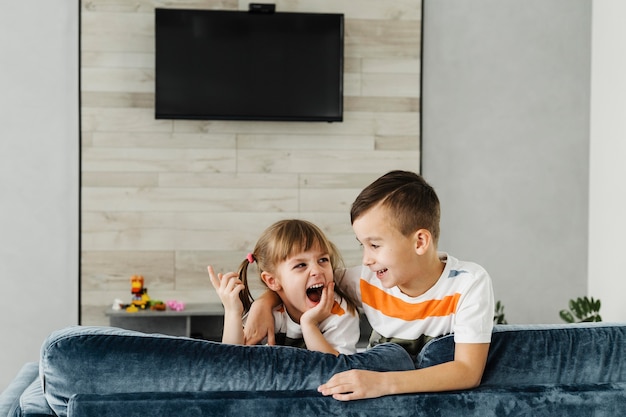 Plano geral de irmãos e televisão na parede