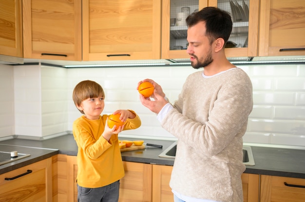 Plano médio de criança e pai na cozinha