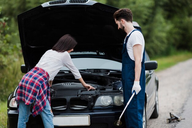 Plano médio de homem e mulher, verificação de motor