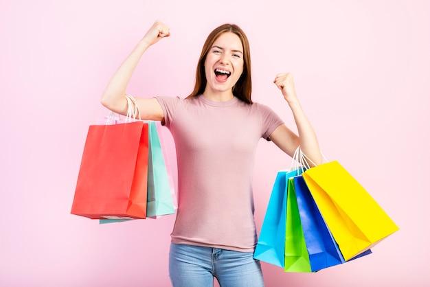 Foto grátis plano médio, de, mulher feliz, segurando sacolas de compras