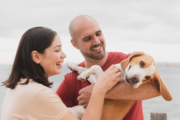 Playign de casal com cachorro ao ar livre