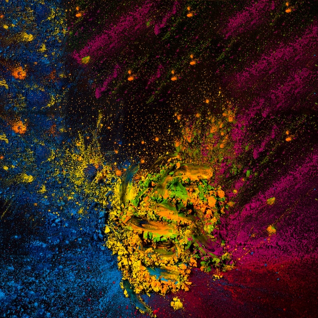 Foto grátis pó de holi abstrata manchado sobre a superfície preta