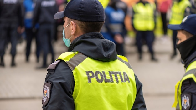 Policial e pessoas protestando por eleições antecipadas em frente ao prédio do Tribunal Constitucional