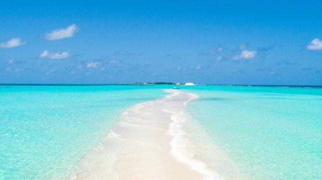 Ponta estreita de uma ilha coberta por areia limpa e água limpa de ambos os lados
