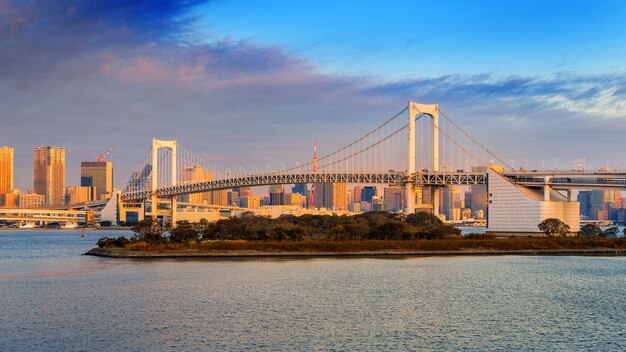 Ponte de arco-íris e paisagem urbana de Tóquio ao nascer do sol, Japão.