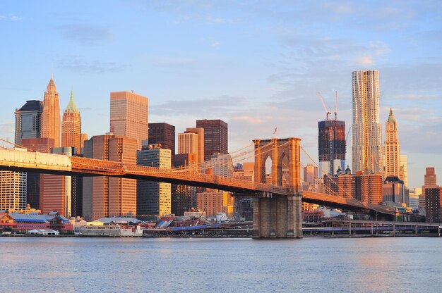 Ponte do Brooklyn com horizonte inferior de Manhattan pela manhã com nuvem colorida sobre East River em Nova York