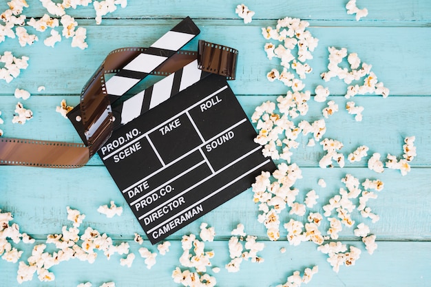 Foto grátis popcorn em torno de clapperboard e filme