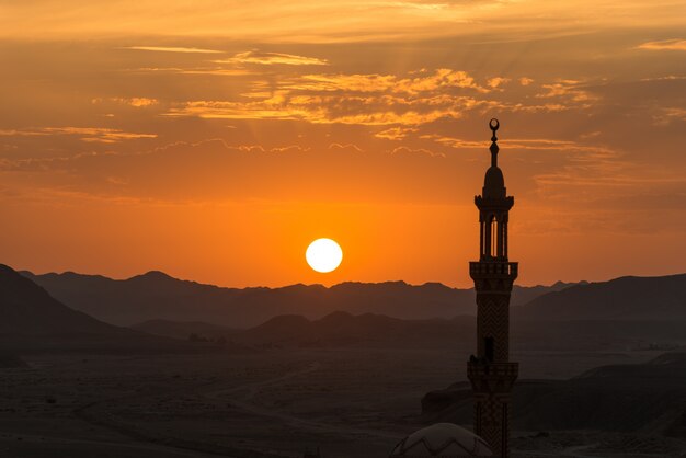 Pôr do sol com a mesquita musulmana em primeiro plano