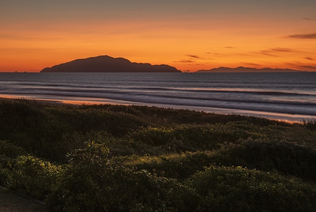 Pôr do sol de tirar o fôlego na Praia Otaki na Costa Kapiti, na Ilha do Norte da Nova Zelândia