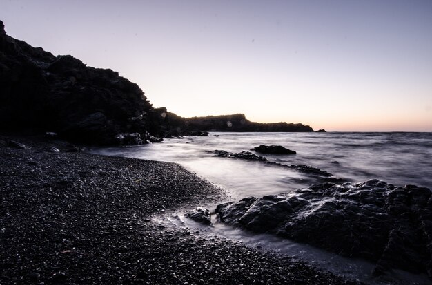 Pôr do sol em uma praia de pedras