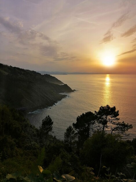 pôr do sol hipnotizante refletido no oceano na cidade turística de San Sebastian, Espanha