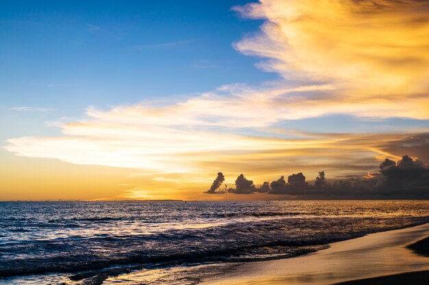 pôr do sol no oceano. lindo céu brilhante, reflexo na água, ondas.