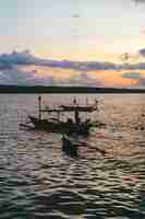 Foto grátis pôr do sol sobre o oceano, barcos de pesca. bali, indonésia