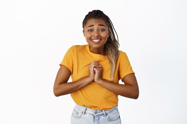 Por favor, linda garota negra pedindo favor, implorando e sorrindo, precisa de algo sobre o fundo branco