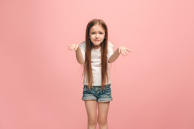 Foto grátis por que é que. belo retrato feminino com metade do corpo na parede rosa na moda. jovem adolescente emocional surpresa, frustrada e desnorteada. emoções humanas, conceito de expressão facial.