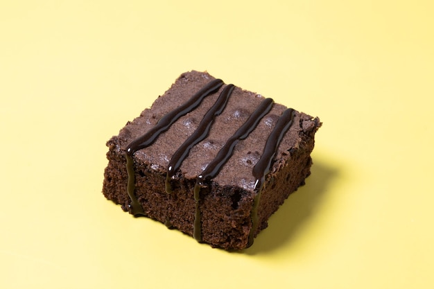 Foto grátis porção de brownie de chocolate em fundo amarelo