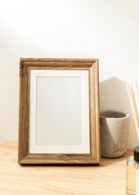 Porta-retrato decorativo em branco na mesa de madeira