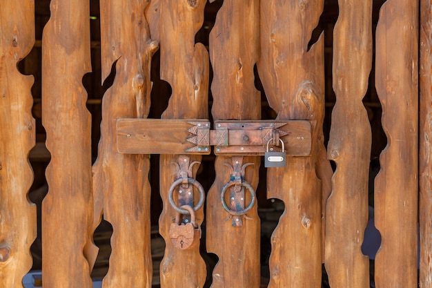Portão de tábuas de madeira com fechaduras e parafusos metálicos, fundo de textura de tábuas de madeira pastel