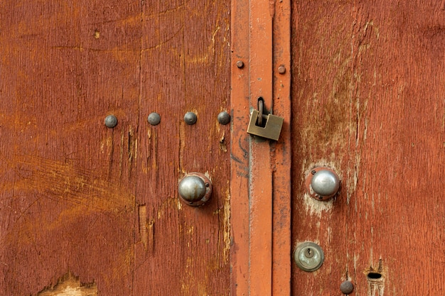 Portas de madeira envelhecida com rebites e fechadura de metal