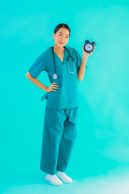 Portriat bela jovem médico asiático mulher mostrar relógio ou alarme