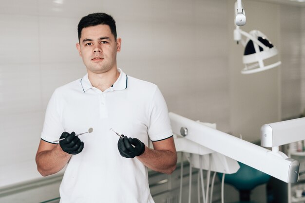 Posando o dentista segurando o equipamento