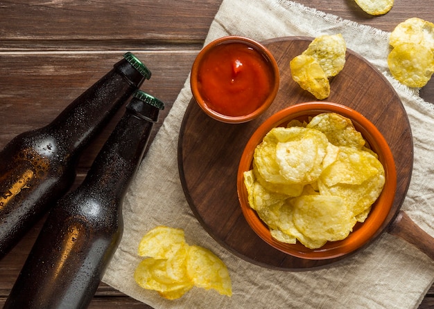 Foto grátis posição plana de garrafas de cerveja com batatas fritas e ketchup