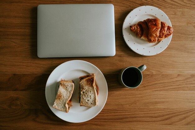 Posição plana de um laptop e café da manhã em um café